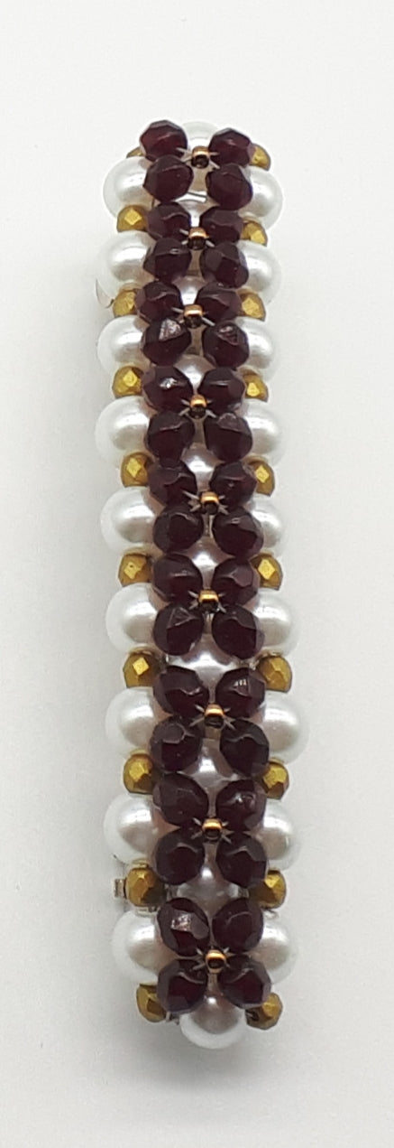 Garnet and gold colored beaded flower pattern hair barrette on a white pearl base.