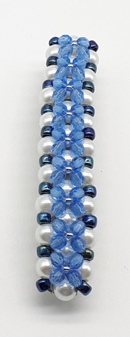 Blue beaded flower pattern hair barrette on a white pearl base.