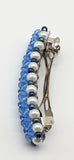 Blue beaded flower pattern hair barrette on a white pearl base.