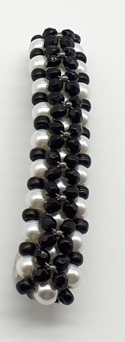 Black beaded flower pattern hair barrette on a white pearl base.