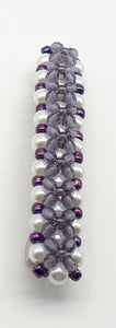 Purple beaded flower pattern hair barrette on a white pearl base.