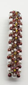 Brown and yellow beaded flower pattern hair barrette on a white pearl base.