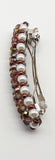 Brown and yellow beaded flower pattern hair barrette on a white pearl base.